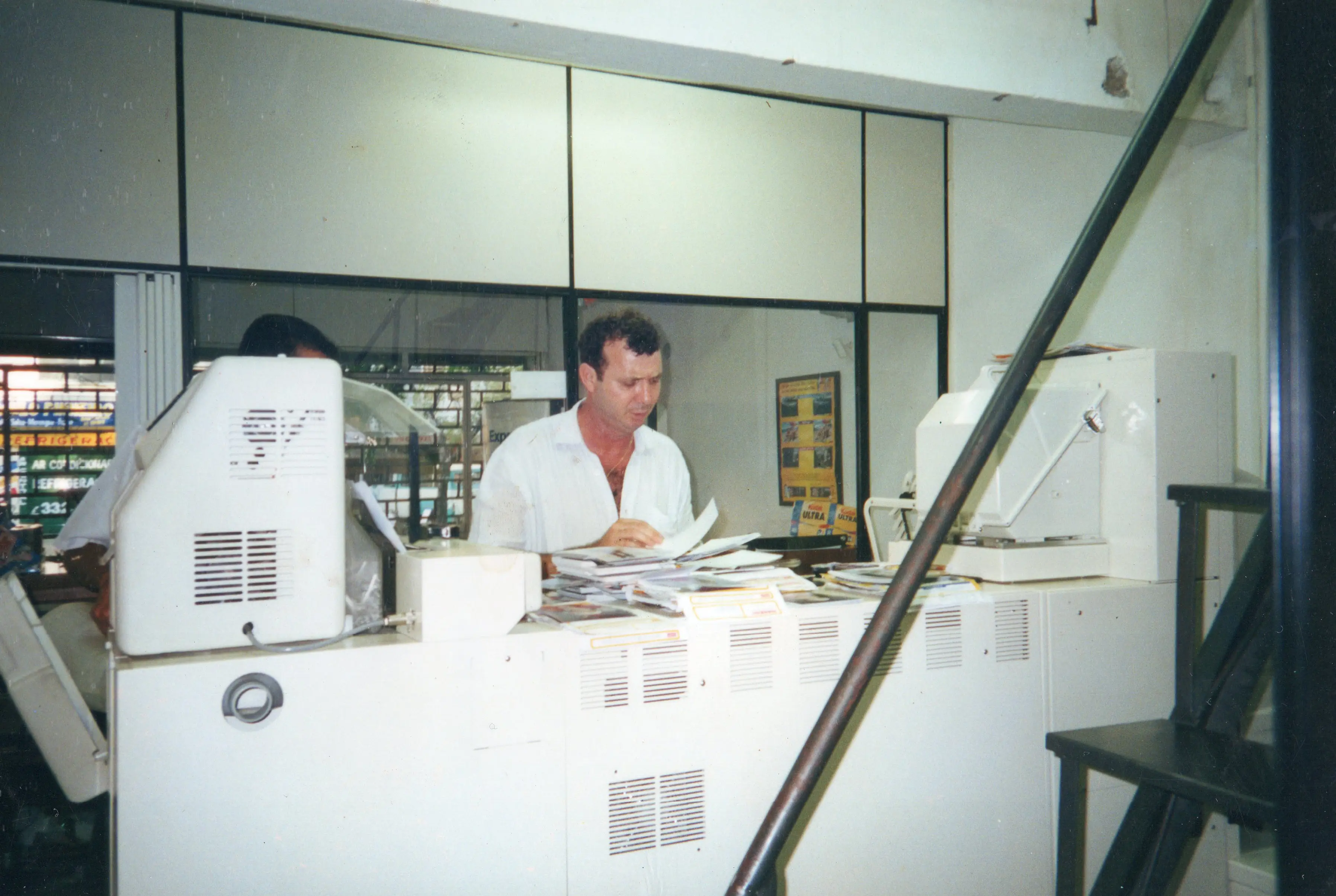 Equipe Fotomania no balcão de atendimento em 1997